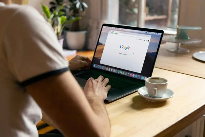 A man pasting something into the Google search bar on a laptop. A man pasting something into the Google search bar on a laptop.