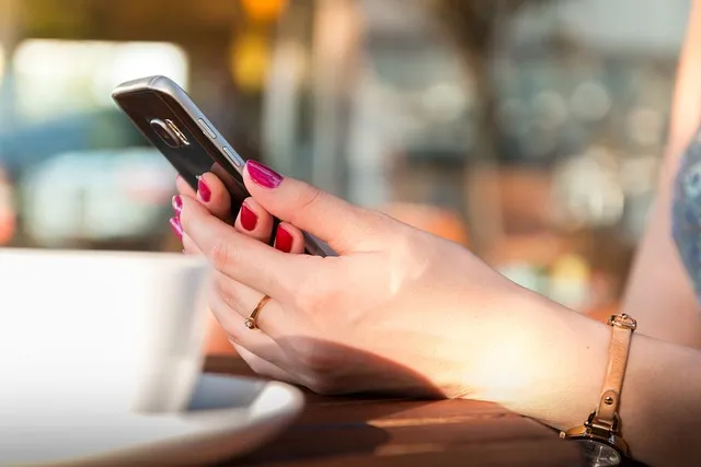 A pair of hands holds a phone. A pair of hands holds a phone.