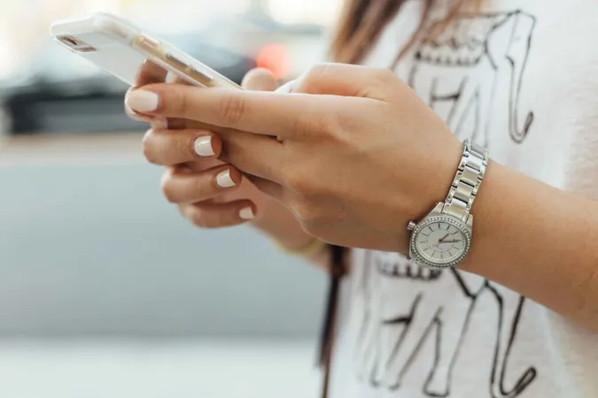 A young woman holding a phone. A young woman holding a phone.